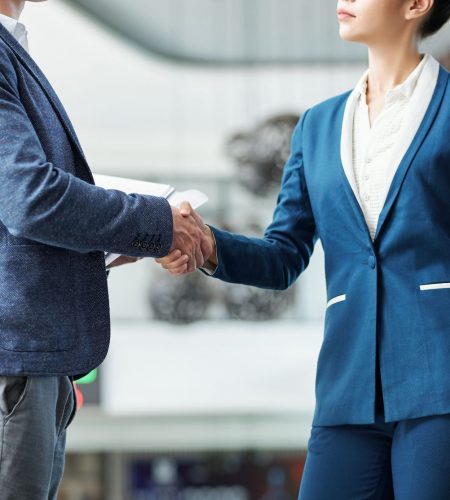 cropped-image-serious-young-male-female-entrepreneurs-shaking-hands (1)